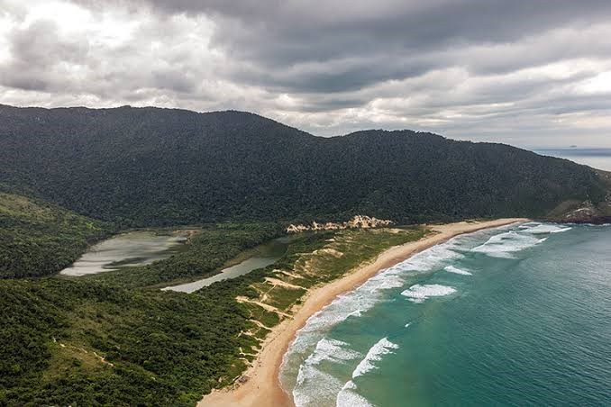 Vista aérea da Lagoinha do Leste com a lagoa em formato de S e o mar ao fundo